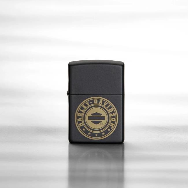 Lifestyle image of Harley-Davidson?« Laser Engrave Logo Black Matte Lighter, standing on a reflective sheet of metal