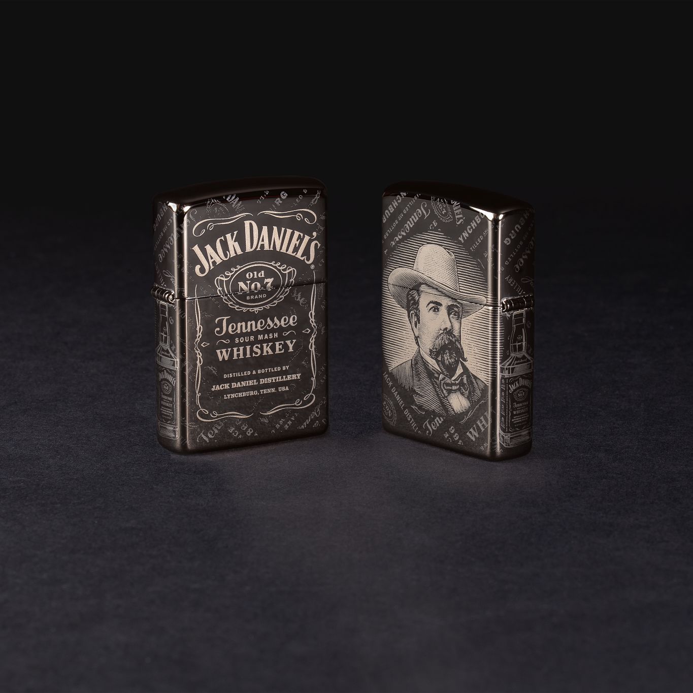 Lifestyle image of two Jack Daniel's?« Photo Image 360?« Black Ice?« Windproof Lighters standing in a black background. One lighter is showing the front and the other is showing the back.