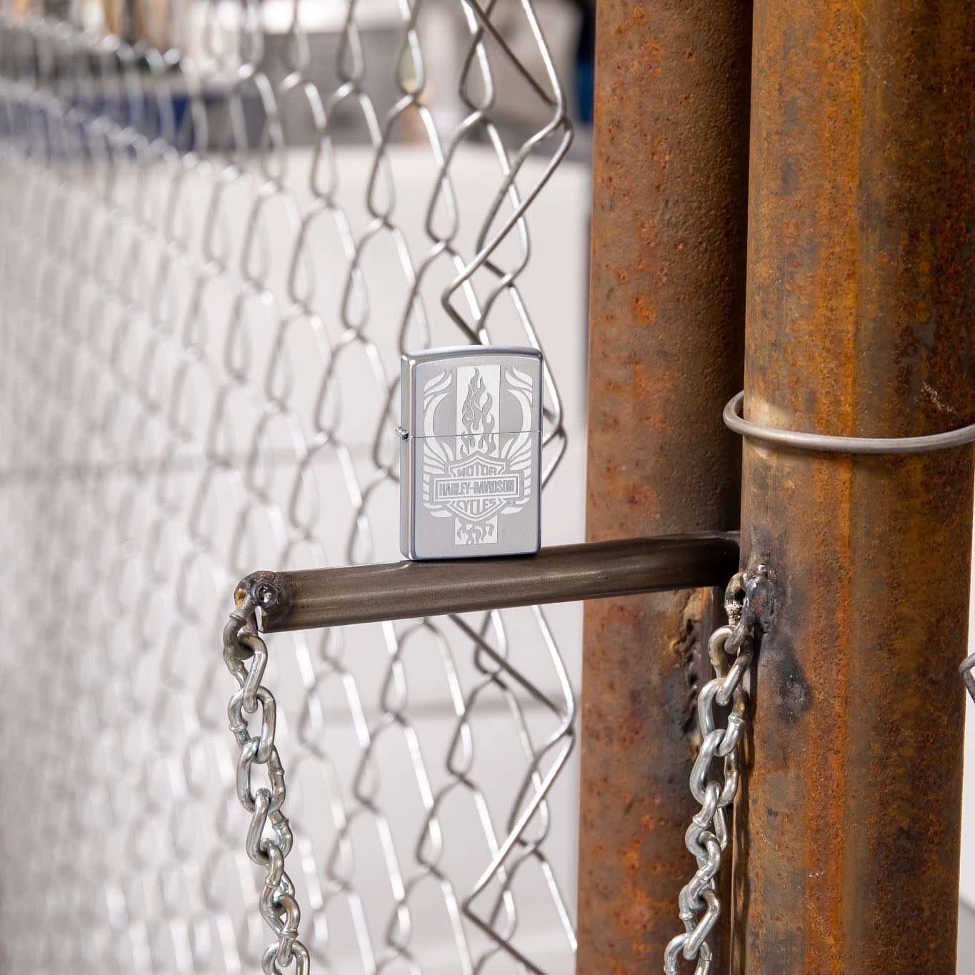 Lifestyle image of Harley-Davidson?« Luster Etch Satin Chrome Windproof Lighter standing in a garage scene.