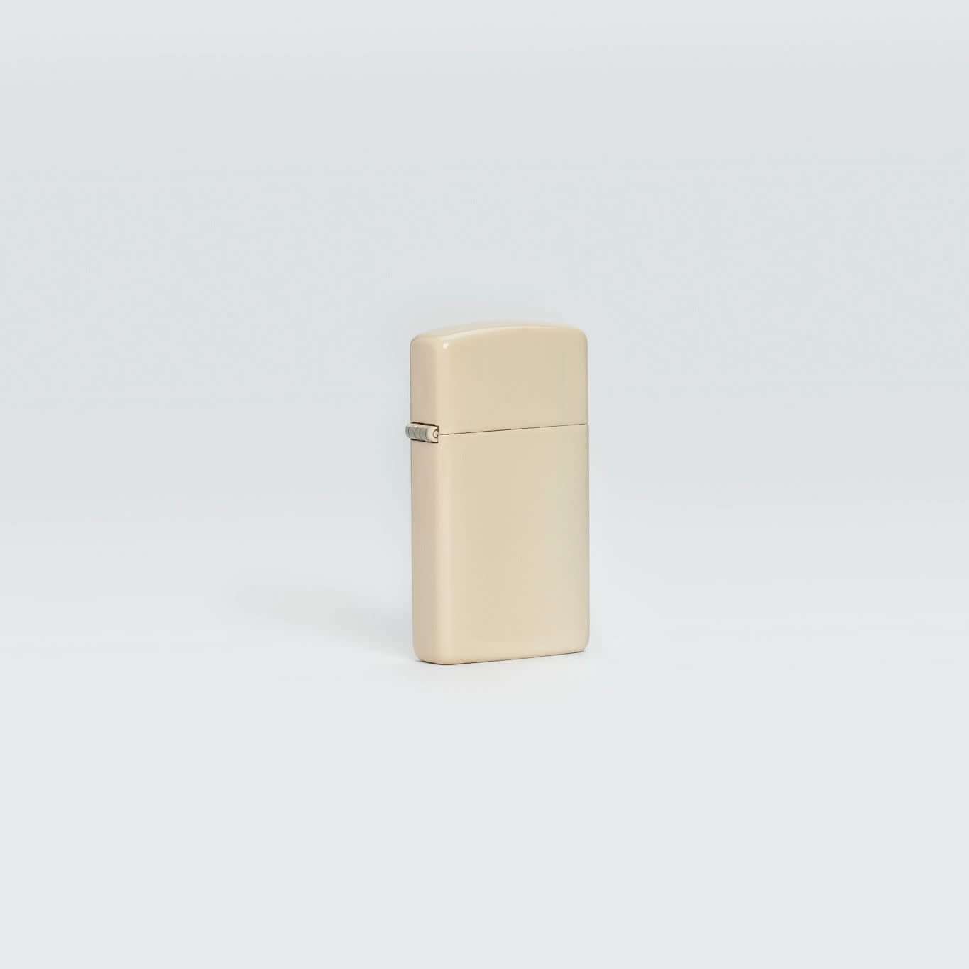 Lifestyle image of Slim?« Flat Sand Windproof Lighter standing in a grey scene.